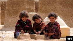 Afghan children pose for a photograph near their temporary shelter in Mazar-e Sharif, April 24, 2015