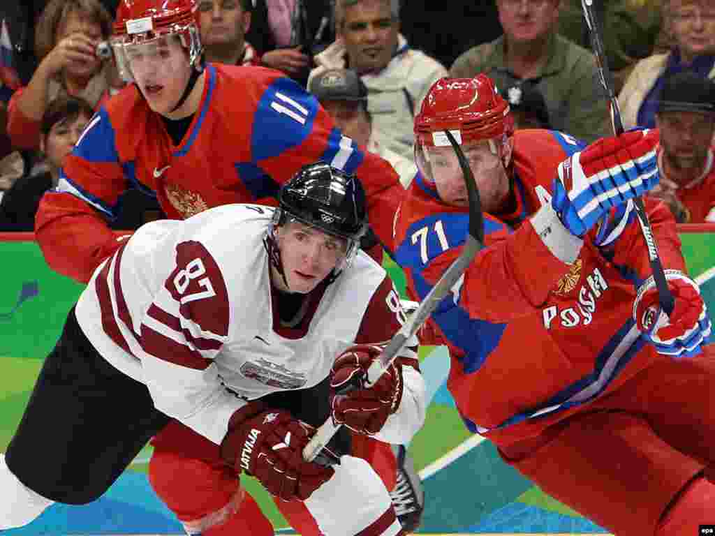مسابقه هاکی بین تیم های لتونی و روسیه - Russia's Ilya Kovalchuk (2-R) and Evgeny Malkin (L) fights for the puck with Latvia's Gints Meija (L) during their Group match of Men's Ice Hockey at the Vancouver 2010 Olympic Game, Vancouver, Canada, Friday 16 February 2010.