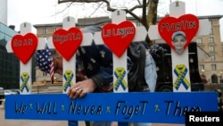 A man puts up a handmade memorial for victims of the 2013 Boston Marathon bombings near the race's finish line in Boston, Massachusetts, on April 15. 