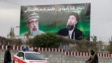 An Afghan man rides on his bicycle past a banner with pictures of Afghan warlord Gulbuddin Hekmatyar in Kabul on May 2.