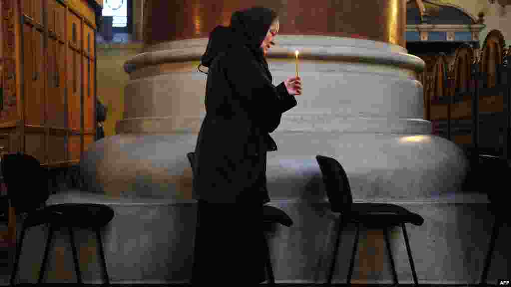 A woman holds a candle at the St. Marko Church in Belgrade during a memorial service for the victims of the 1999 NATO air campaign against Serbia and Montenegro. (AFP/Andrej Isakovic)