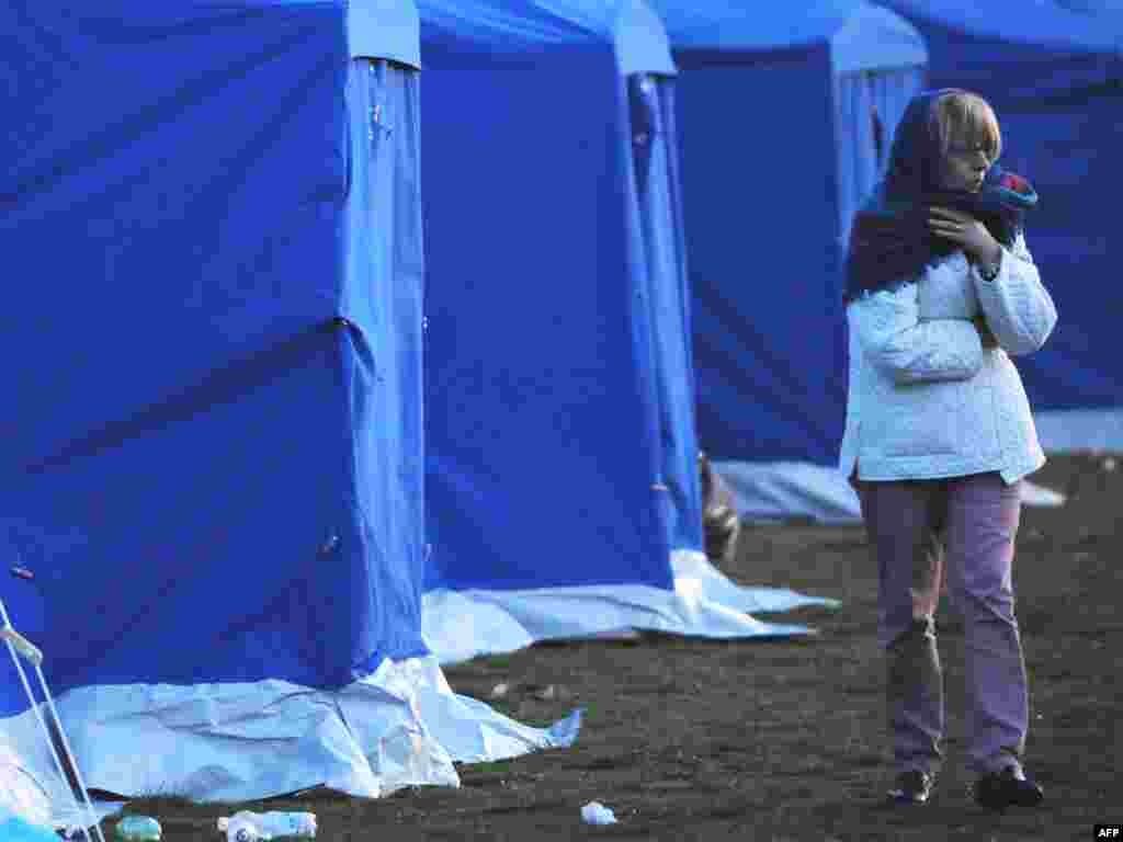 Italy -- A woman wakes up after spending the night at a stadium in the Abruzzo capital of L'Aquila, 07Apr2009 - ITALY, L'Aquila : People wake up on April 7, 2009 after spending the night in a stadium in the Abruzzo capital of L'Aquila, the epicenter of an earthquake that struck on April 6. The death toll from the powerful quake that rocked central Italy has risen to 179, with 34 people reported missing, rescue workers in the town of L'Aquila said on April 7.