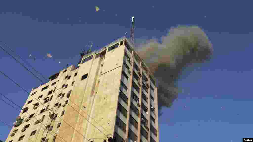 Smoke and debris are seen after an Israeli air strike on the office of the Hamas television channel Al-Aqsa in a building that also houses other media in Gaza City.