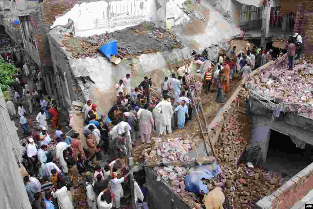 Rescue workers and residents search for worshippers in the rubble of a collapsed mosque in Lahore. Twenty-four worshippers were killed when the roof collapsed after heavy rain.