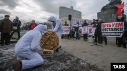 Communist Party supporters dressed as white bears saw through a replica of a Russian ruble coin during a protest rally against the policies of the Russian government in front of parliament in Moscow on December 22.