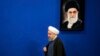 Iranian President Hassan Rouhani walks past a picture of the Supreme Leader Ayatollah Ali Khamenei as he arrives to a press conference at the presidency compound in Tehran, Iran, Monday, April, 10, 2017.