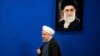 Iranian President Hassan Rouhani walks past a picture of the Supreme Leader Ayatollah Ali Khamenei as he arrives to a press conference at the presidency compound in Tehran, Iran, Monday, April, 10, 2017.