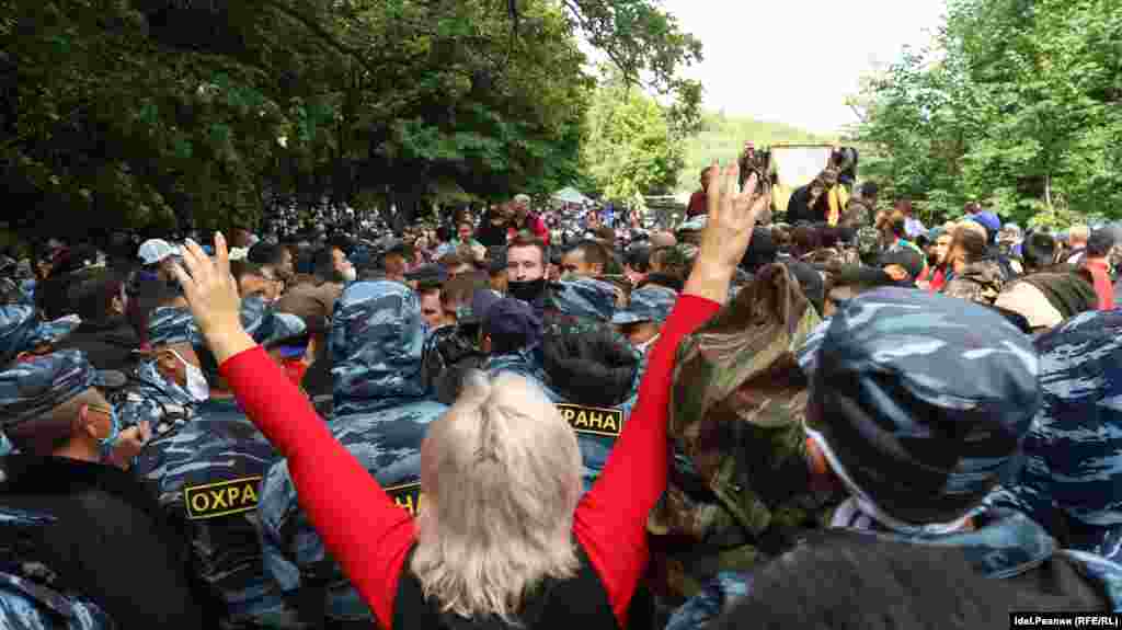 Сотрудники охранной фирмы стоят напротив протестующих. 15 августа.