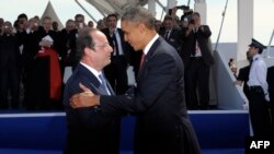 U.S. President Barack Obama (right) talks with French President Francois Hollande during the international D-Day commemoration ceremony in Normandy on June 6.