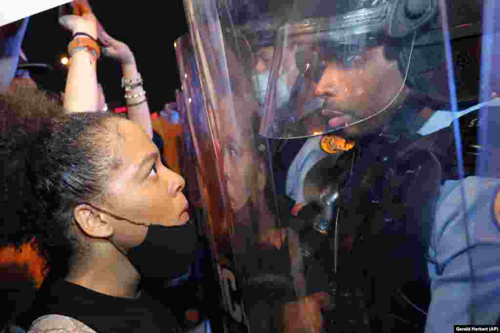 Një protestuese dhe një zyrtar policor shikojnë njëri-tjetrin, në Nju Orlliens. &nbsp;
