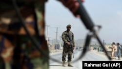 Afghan National Army soldiers stand guard at a checkpoint on the Jalalabad-Kabul road.