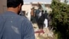 Afghans inspect the site of a suicide attack in Lashkar Gah on October 9.