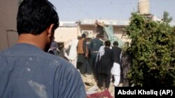 Afghans inspect the site of a suicide attack in Lashkar Gah, the capital of Helmand Province, on October 9.