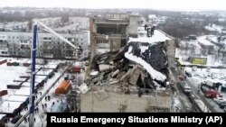 Rescue workers at the scene of the destroyed top floor of an apartment building in Shakhty on January 14.