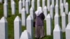 Egy nő sétál a srebrenicai mészárlás áldozatainak sírjai között a Srebrenica melletti potočari emléktemetőben