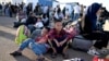 Afghan refugees rest with their belongings after arriving at the zero point of the Islam Qala border crossing between Afghanistan and Iran on June 28, 2025, following their deportation from Iran.