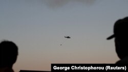 Helikopter sa kanisterima za vodu učestvuje u gašenju požara nedaleko od Larnake 3. jula 2021.