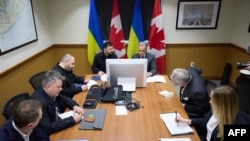 უკრაინის პრეზიდენტი ვოლოდიმირ ზელენსკი და კანადის პრემიერმინისტრი მარკ კარნი (ცენტრში) ჰალიფაქსში (კანადა) მიმდინარე შეხვედრისას. 27 დეკემბერი, 2025 წელი.