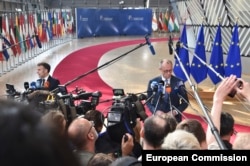 Зліва направо: Емманюель Макрон, президент Франції, Фрідріх Мерц, канцлер Німеччини спілкуються з пресою перед початком саміту у Брюсселі 19 березня 2026 року