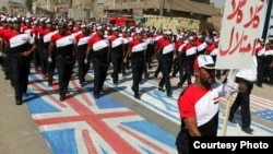 Supporters of Muqtada al-Sadr march in the street and trample on the Israeli, British, and U.S. flags in Baghdad in May.