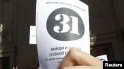 An opposition supporter holds up a leaflet with the number "31" on it during a rally in Moscow on May 31.