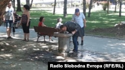 Човек пие вода парк во Скопје.