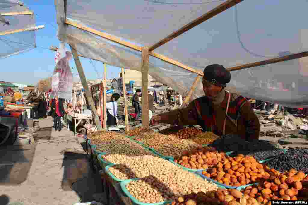 A seller of dried fruit and nuts plies her wares in the central market in the southern Kyrgyz city of Osh. (RFE/RL/Ernist Nurmatov)