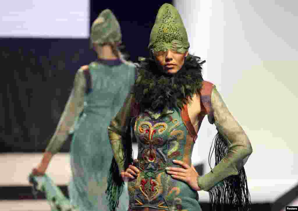 Models present creations by designer Talshyn Kokenova during the OPEN WAY National Contest of Young Designers in Almaty on September 27, 2012.