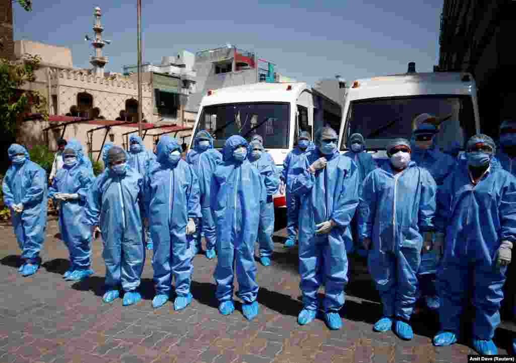 Doctors wearing protective suits are briefed before they start collecting swab from people, who are under home quarantine, to test for coronavirus disease