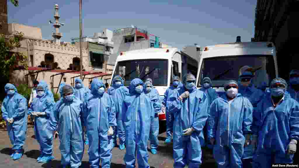 Doctors wearing protective suits are briefed before they start collecting swab from people, who are under home quarantine, to test for coronavirus disease