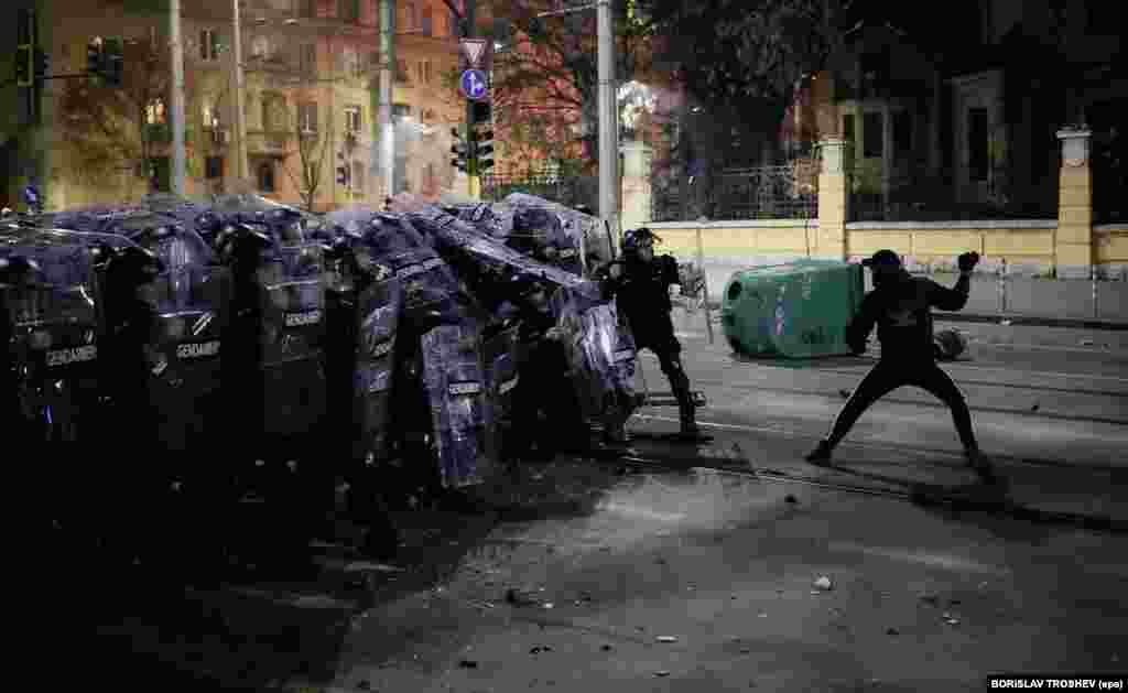 A protester prepares to hurl an object at police.The protests come as Bulgaria prepares to adopt the European common currency, the euro, on January 1, 2026.
