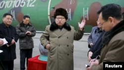 کیم جونگ اون در حال بازدید از تجهیزات نظامی و کلاهک هسته‌ای که کره شمالی می‌گوید قابل نصب بر موشک است