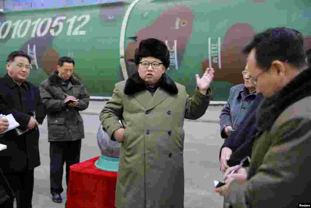 Северокорейский диктатор Ким Чен Ын в окружении военных и инженеров-ядерщиков. Место съемки неизвестно. Март 2016 года.