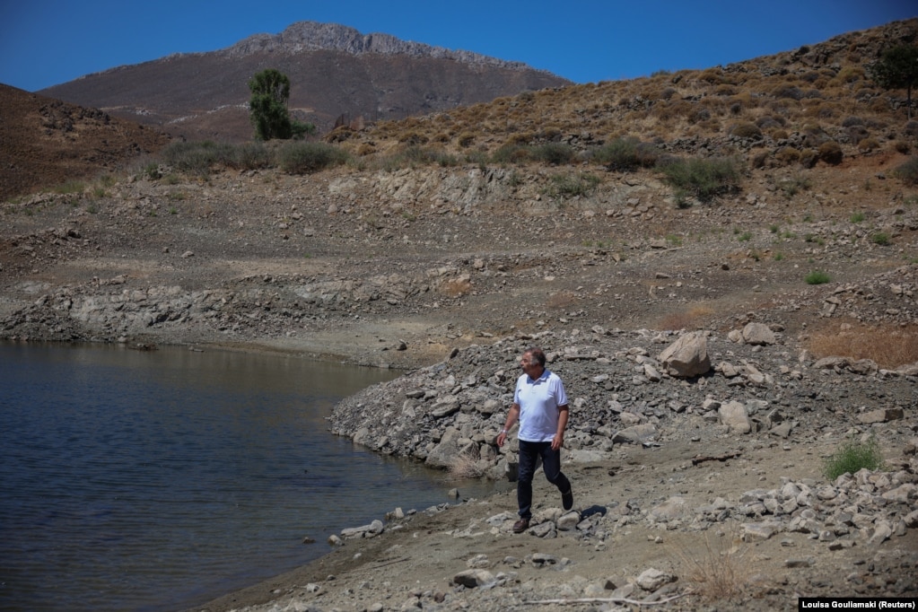 Kryetari i ishullit Astapalaia të Greqisë, Nikos Komineas, ecën nëpër pjesën e tharë të rezervuarit artificial të ujit pranë fshatit Livadi. 13 korrik 2026.