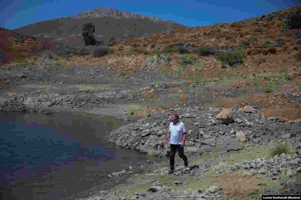 Kryetari i ishullit Astapalaia të Greqisë, Nikos Komineas, ecën nëpër pjesën e tharë të rezervuarit artificial të ujit pranë fshatit Livadi. 13 korrik 2026.