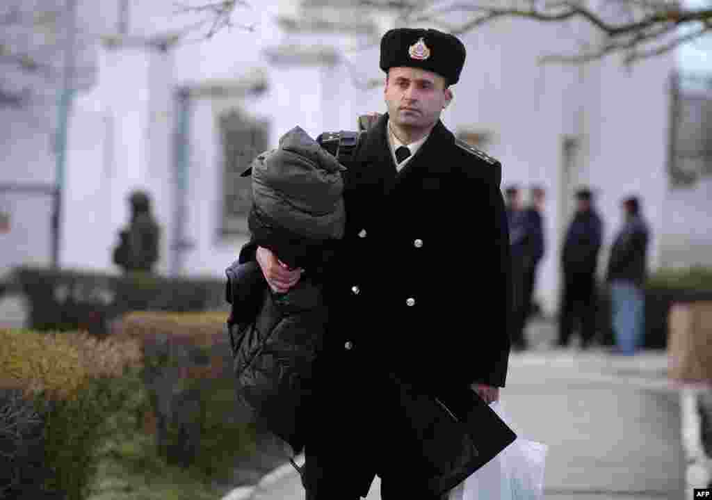 Український офіцер залишає базу південної штаб-квартири військово-морського флоту в Новоозерному після того, як вона була захоплена російськими військами, 19 березня 2014 року