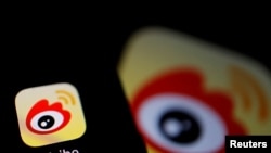 Логотип главной китайской социальной сети Weibo, полностью подконтрольной и прозрачной для спецслужб и государственной цензуры, на экране смартфона