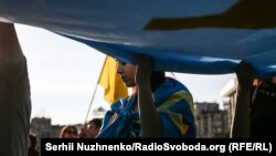 Кримчанка тримає велике полотно кримськотатарського прапора на Майдані Незалежності. Київ, 26 червня 2018 року. Ілюстраційне фото