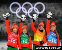Динара Әлімбекова (сол жақтан санағанда екінші) мен командаластарының олимпиада чемпионы ретінде марапатталған сәті. Пхенчхан, 22 ақпан 2018 жыл