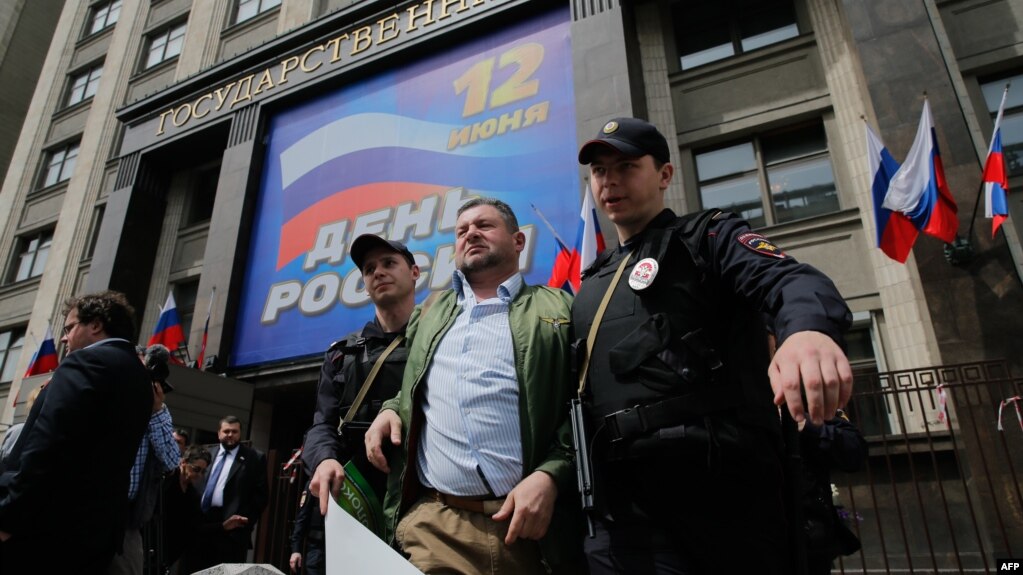 Russian police detain a man during a protest against the city's plan to knock down Soviet-era apartment blocs in front of the State Duma in central Moscow on June 9.