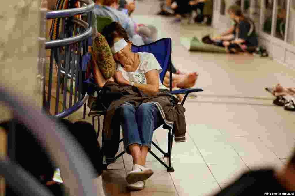 Një grua me sytë e mbuluar për të fjetur, gjatë strehimit në metro, më 8 korrik.