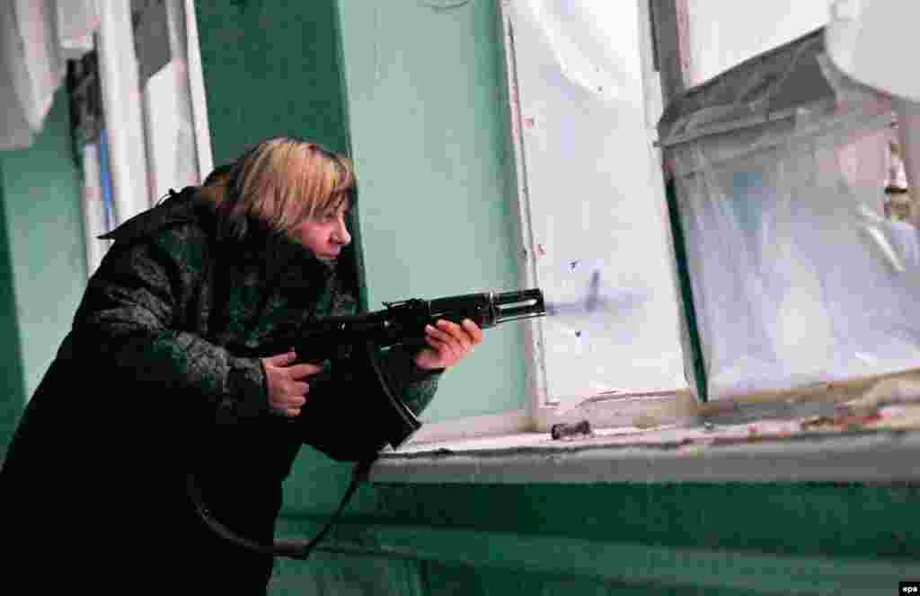 An armed pro-Russia militant holds her position inside a damaged school in the village of Zaytseve in the Donetsk region. (epa/Alexander Ermochenko)