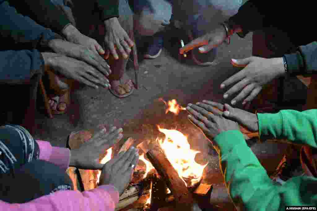 &nbsp;People gather around a fire to beat the cold in Lahore, Pakistan.