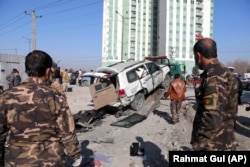 Afghan security personnel inspect the site of a bomb attack in Kabul on December 15, 2020, that killed Kabul's deputy provincial governor, Mahbobullah Mohibi.