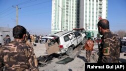 Afghan security personnel inspect the site of a bomb attack in Kabul on December 15.