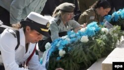 Israeli officers light candles near the mass grave at Babyn Yar in Kyiv.