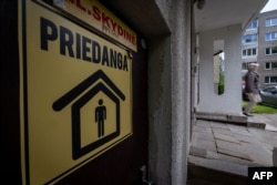 Жоўтая налепка з надпісам «Priedanga» (Сховішча)