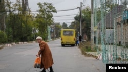 Жінка перетинає вулицю в Херсоні, який на кілька днів залишився без обстрілів на тлі перемир’я навколо Олешків, жовтень 2026 року