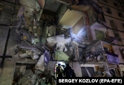 Ukrainian rescuers work at the site of a deadly Russian glide-bomb attack on a nine-story residential building in Kharkiv in October.