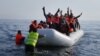 Syrian student Daoud Daoud (center, arms raised) was one of 4,000 new arrivals to the island of Lesbos during the last weekend in February. 